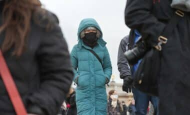 Une journée froide et grise : des passants emmitouflés dans des manteaux, illustrant les conditions hivernales et une météo glaciale.