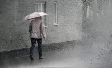 Une personne avec un parapluie marchant sous une météo chaotique