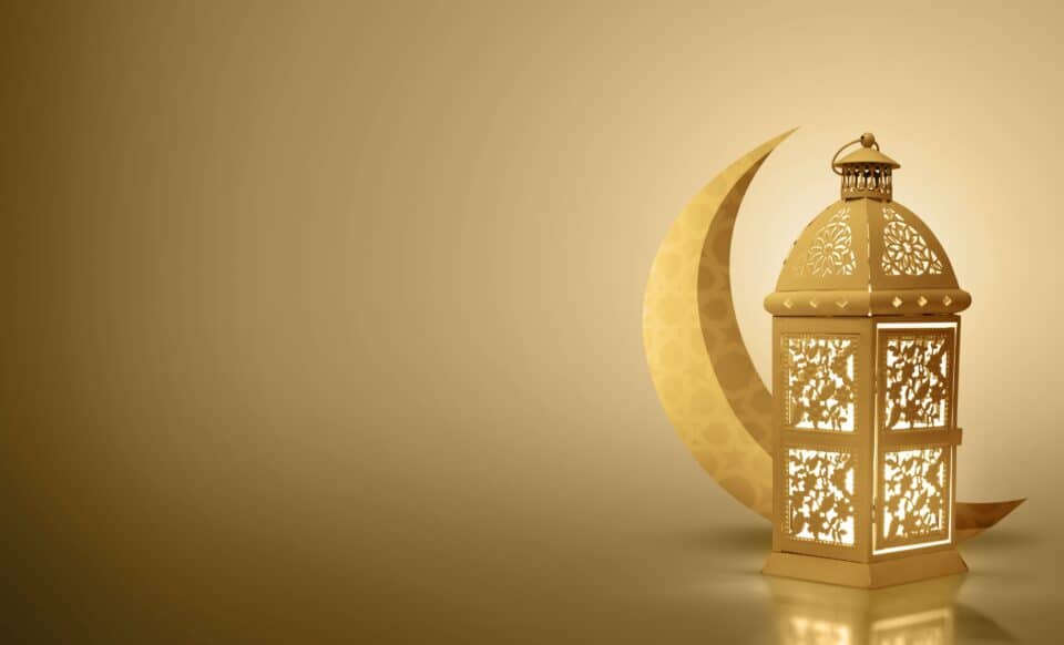 Une lanterne décorative dorée et un croissant de lune symbolisent le mois sacré du Ramadan, évoquant spiritualité et tradition.