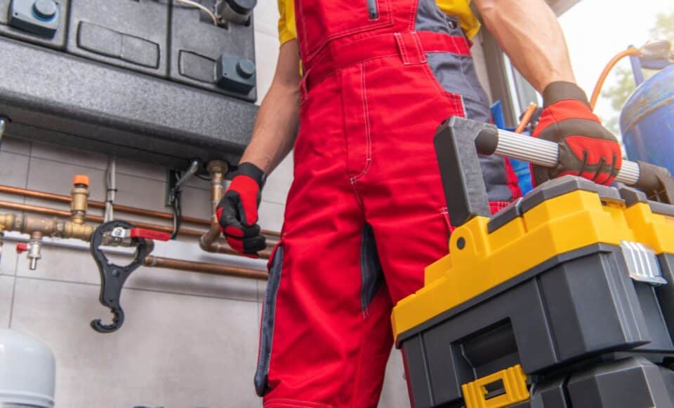 un technicien en tenue de travail qui porte une malette