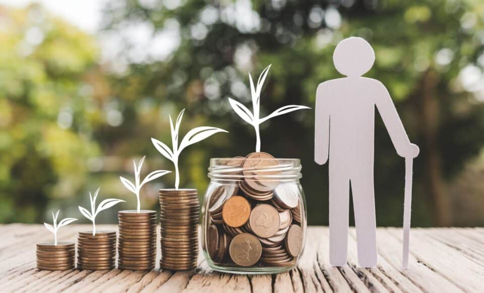 Une figurine en papier représentant un retraité devant un bocal rempli de pièces