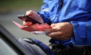 Un agent de police contrôle les papiers d'un conducteur lors d'une infraction liée aux délits routiers.