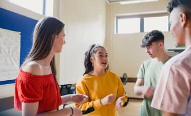 Un groupe de jeunes discute activement dans une salle, illustrant un atelier ou une session de travail collaboratif, possiblement lié à l'orientation professionnelle ou au développement de compétences, illustrant les avantages de la plateforme Youngs Job.