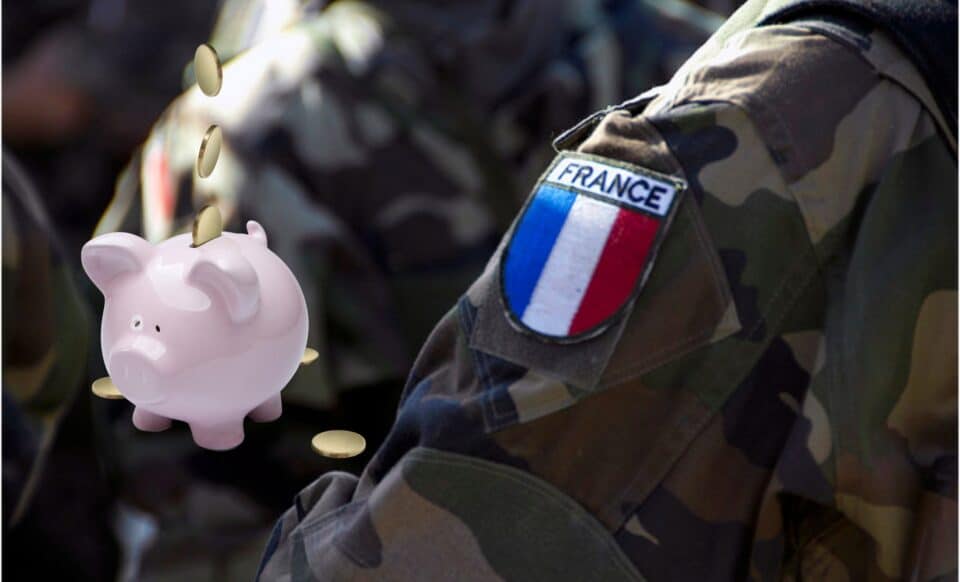 Un tirelire avec des pièces tombant à côté d’un uniforme militaire français, illustrant le lien entre épargne et financement de la défense.