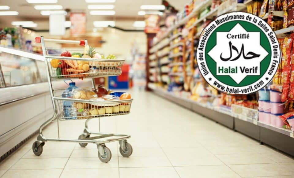 Un caddie rempli de produits alimentaires se trouve dans un supermarché, avec en arrière-plan des rayons bien garnis. Un logo de certification halal est superposé sur l’image, faisant référence aux achats liés au Ramadan.