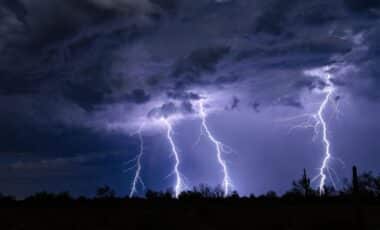 Ciel orageux menaçant avec plusieurs éclairs illuminant la nuit, illustrant une météo instable et violente.