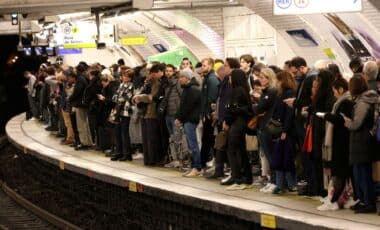 Une foule de voyageurs attend sur un quai de métro en Île-de-France, illustrant l'affluence et les perturbations dans les transports en commun.