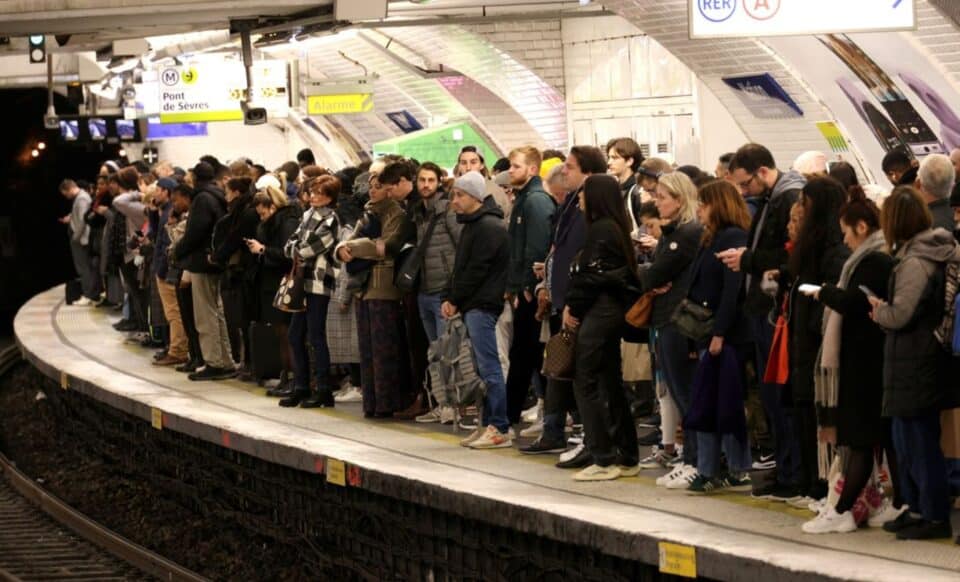 Une foule de voyageurs attend sur un quai de métro en Île-de-France, illustrant l'affluence et les perturbations dans les transports en commun.