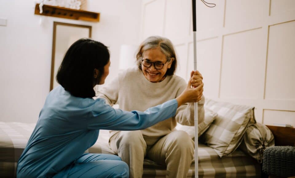 Image d'une personne âgée qui se fait aider par une soignante pour illustrer les aides dédiées aux retraités